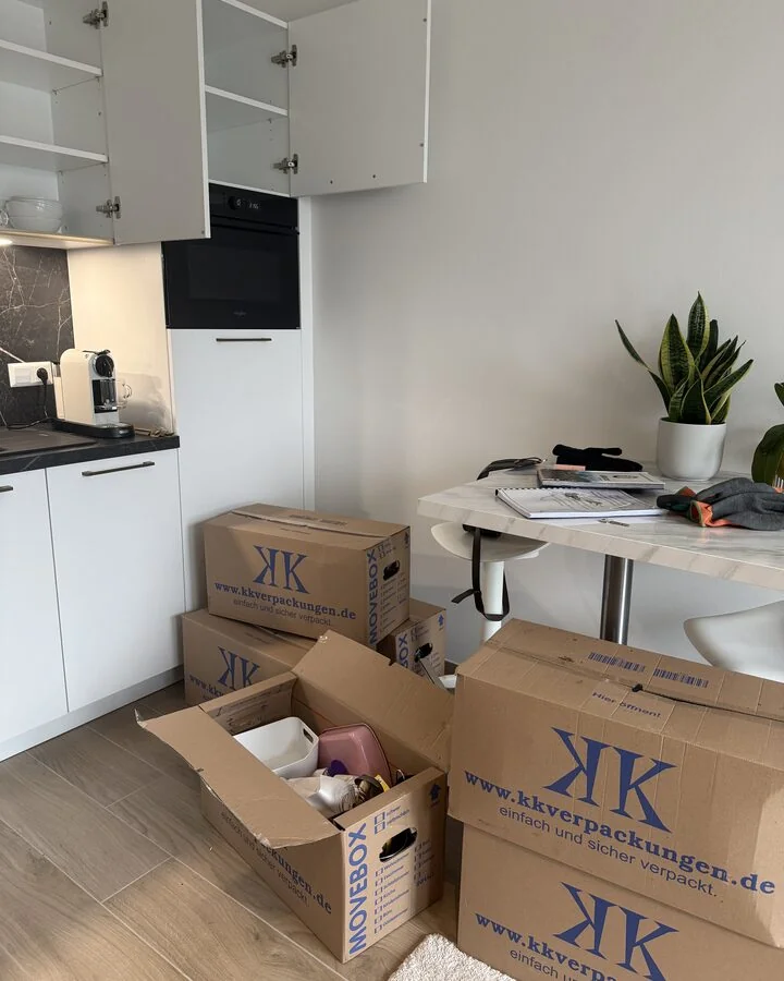 Umzugskartons werden in der Wohnung gepackt